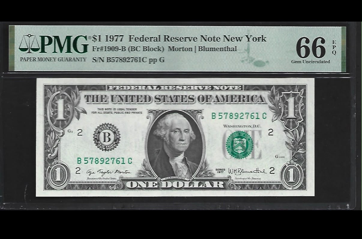 Front of a PMG-graded 1977 one-dollar Federal Reserve Note in its clear holder, showing George Washington and Azie Taylor Morton’s Treasurer signature.